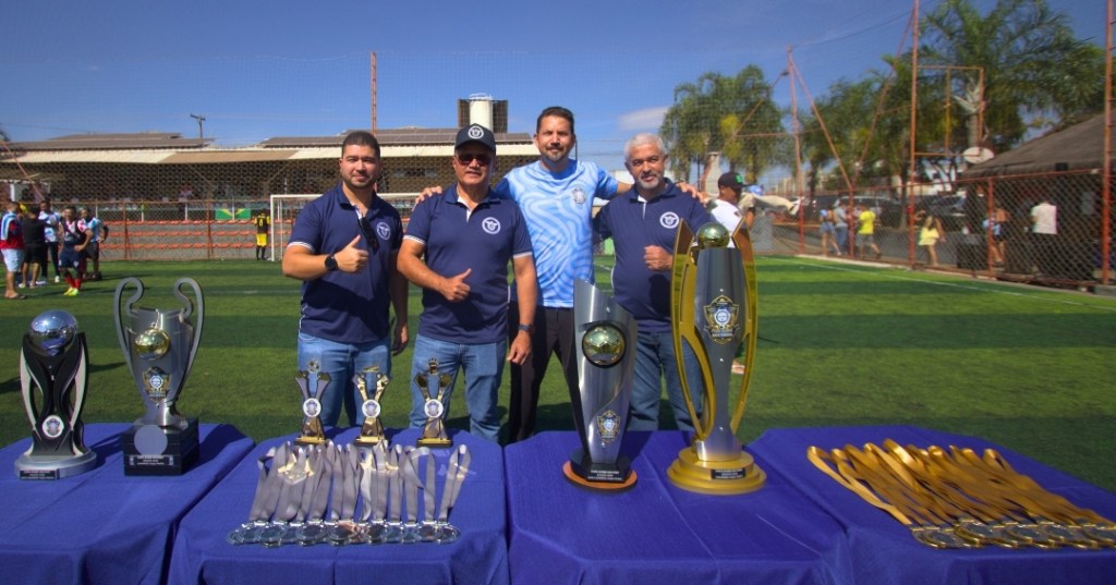 No final da Copa Bares Sechseg está o Presidente Marlos, o vice Leandro, o diretor José e o Daniel, no campo de futebol atrás da mesa de troféus e medalhas.